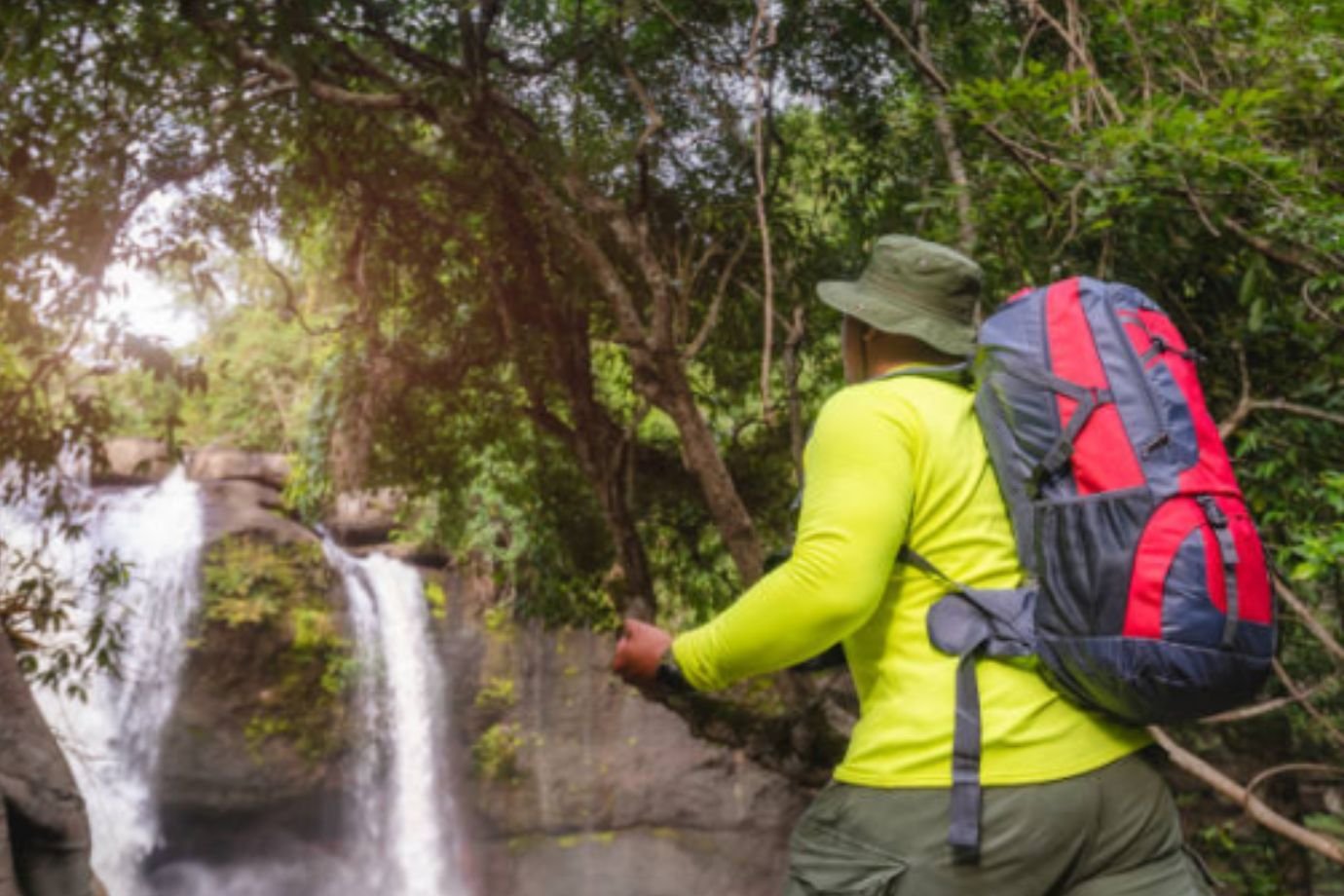 Ecoturistas carregando mochila em trilha ecológica.
